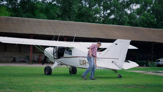 Plane engineer checking airplane on green airdrome. Aircraft preflight inspection