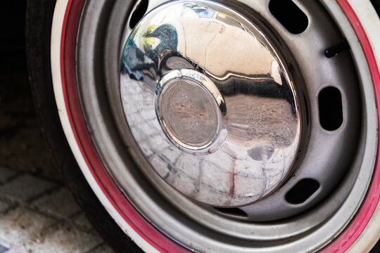 Vintage car wheel with chromed cap and red stripe,
