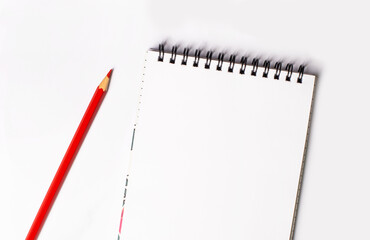Red pencil and blank notepad with space to insert text on a light background. Copy space