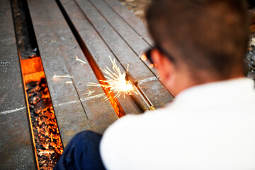 man cutting metal bars or billets with a propane and oxygen torch in the metal industry. qualified...