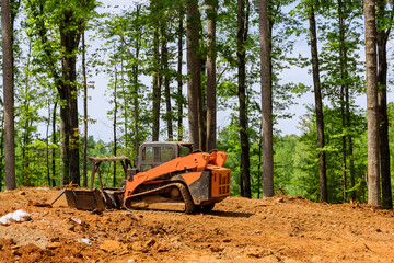 A construction industrial grader is used in the process of leveling the land to prepare it to be...