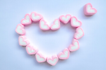 Rows of pink and white heart shaped marshmallow candies. Marshmallows in the shape of a heart on background. Fill heart for full of love , small hearts lined up to form a large heart.