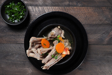 Sup Iga Kambing or Mutton Soup or stewed lamb soup served with sliced ​​tomatoes, and carrots.