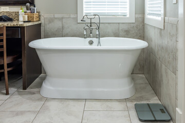 Fototapeta na wymiar Master bathroom freestanding bathtub in a tiled master bathroom