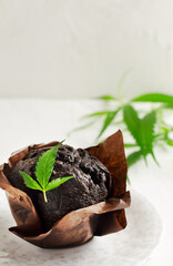 Marijuana cupcake muffins with cannabis leaves. Gluten free. Alternative sweets concept. Vertical orientation. Selective focus.