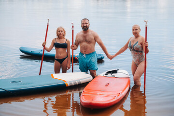 The family spends time together swimming on sup boards on the lake