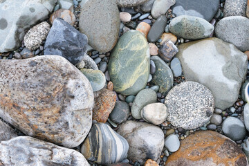 Background of rounded river stones of different colors from the river bank