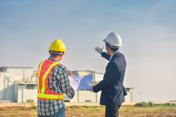 Asian team Construction engineers supervising progress of construction project stand on new factory, Engineering Consulting People on construction site Building inspector.