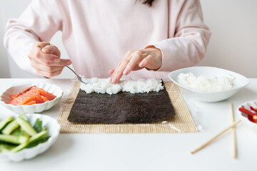 Sushi cooking process, girl makes sushi with different flavors.