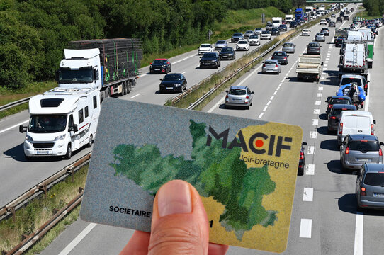 Carte de soci&eacute;taire des assurances Macif tenue en main en gros plan avec une route au second plan