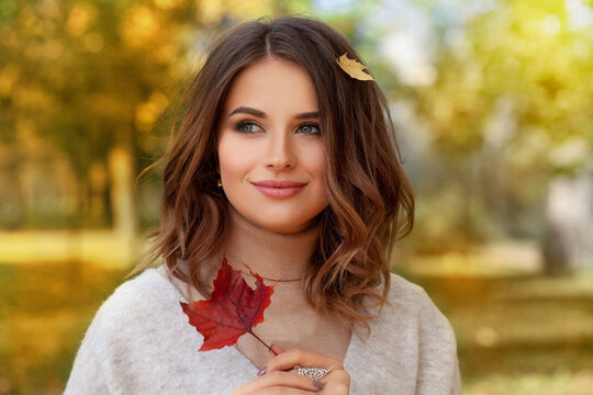 Outdoor atmospheric fashion photo of young attractive woman with lonh bob hairstyle in autumn landscape