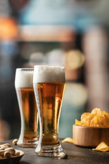 Two glasses of light foamy beer with drops on the side in bar. Alcohol, entertainment, traditional drinks, Oktoberfest atmosphere concept. Copy space