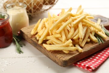Delicious french fries served on white wooden table, closeup