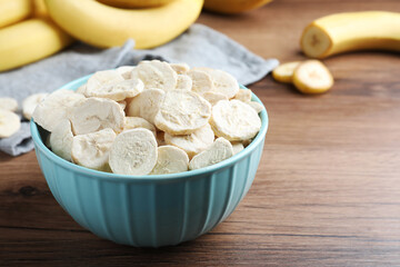 Freeze dried and fresh bananas on wooden table, closeup. Space for text