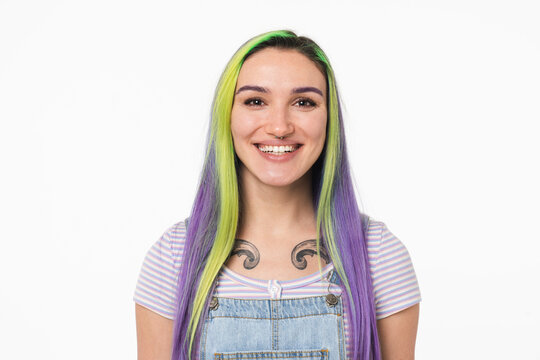 Closeup cropped portrait of young teenage girl woman hipster with dyed colorful hair and tattoo smiling with toothy smile isolated in white background
