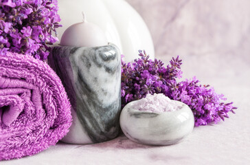 Lavender flowers, candle in the marble candlestick, aromaitic bath salt and towels. Concept for...