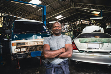 Arms crossed of auto mechanic in the garage.