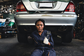 Woman mechanic fixing the car suspension.