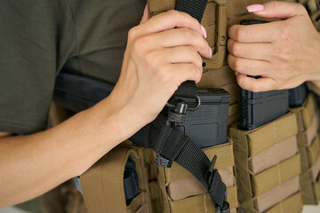 Military woman in a bulletproof vest and with a weapon