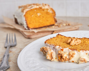 Slice of homemade carrot cake with sugar frosting and nuts. Food concept