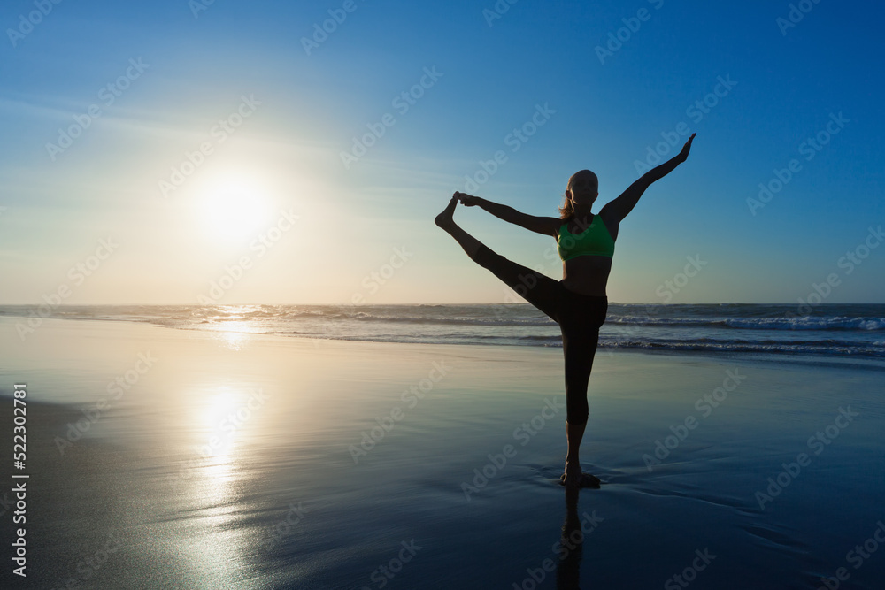 Wall mural Black silhouette of active woman stretching at yoga retreat on sunset beach, sky with sun, ocean surf background. Travel lifestyle, people outdoor activity, family summer vacation on tropical island. - Wall murals