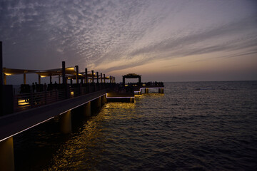 Jeddah's Corniche Beach, after a beautiful sunset and with decorative lighting under the walkway bridge for tourists. 
