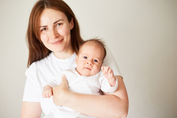 Fototapeta na wymiar Mother holding her newborn baby. Home portrait of newborn baby and mother. Enjoying time together