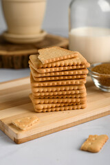 stack of cookies with milk on a wooden table