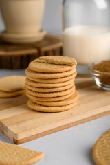 stack of cookies with milk on a wooden table