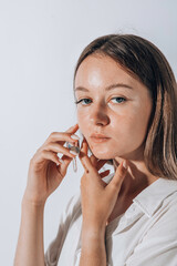 Skin care concept. Beauty portrait of young woman girl holding pipette with cosmetic oil or serum near clean face. choice of cosmetics