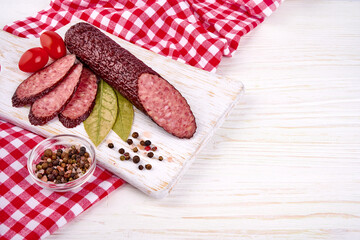 Hot smoked salami sausage on wooden rustic background.