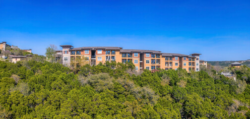 Austin, Texas- Apartment buildings near the cliff of a mountain with trees on the slope