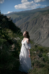 Bride in the mountains wedding image. A beautiful young woman in a wedding dress walks in the mountains.