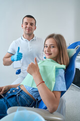 Fototapeta premium Joyous adolescent girl and her stomatologist in dental clinic