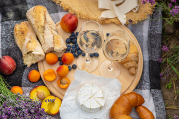 A bottle of wine on a background of a lavender field. Glasses with wine, fruits.