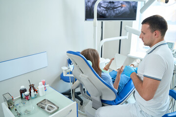 Female patient sitting at consultation in dentist office