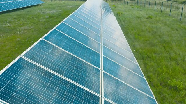 Solar panels in rows, slow aerial movement. Solar battery farm, sustainable energy, ecology