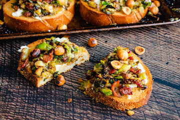 Caramelized Brussels Sprout Toast with Burrata and Bacon: Overhead view of toasted bread topped with vegetables, mozzarella cheese, and bacon