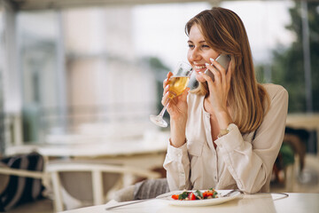 Woman drinking champaign and eating salad