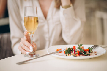 Woman drinking champaign and eating salad