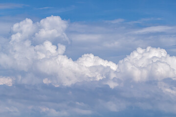 Blue sky with white puffy fluffy clouds, horizontal natural background