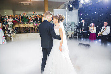 First wedding dance of newlywed couple in restaurant