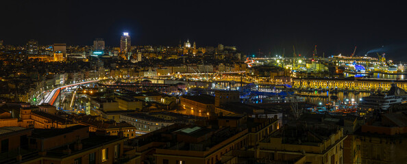 Panoramic view of Genoa at night with the causeway and the buidings of the historic center, Italy