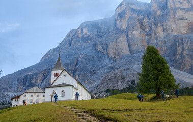 Fototapeta na wymiar BADIA, ITALY, SEPTEMBER 3, 2021 - View of the church and the refuge of Santa Croce under Sass de la Crusc mountain near Badia, Italy.