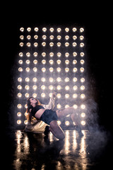 Sexy girl dance on front of spot light wall with smoke