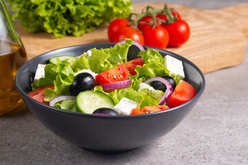 Fresh Greek salad with delicious rucola, spinach, arugula, feta cheese, cucumber, red onion and cherry tomato Healthy and diet food concept.