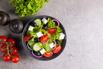 Fresh Greek salad with delicious rucola, spinach, arugula, feta cheese, cucumber, red onion and cherry tomato Healthy and diet food concept.