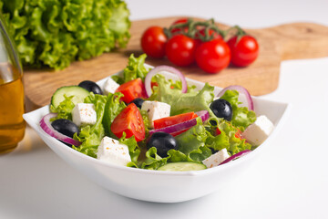 Fresh Greek salad with delicious rucola, spinach, arugula, feta cheese, cucumber, red onion and cherry tomato Healthy and diet food concept.