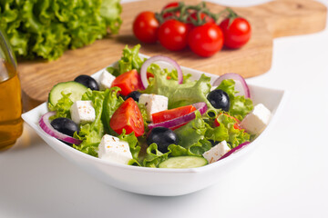 Fresh Greek salad with delicious rucola, spinach, arugula, feta cheese, cucumber, red onion and cherry tomato Healthy and diet food concept.