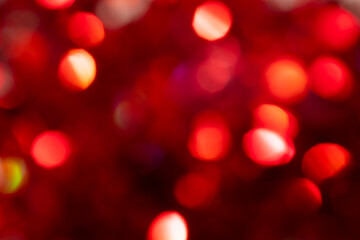 Multicolored bokeh on a red blurred background. Multicolored bokeh on a red blurred background. Festive background can be used for postcards for New Year, Christmas, Valentine's Day.
